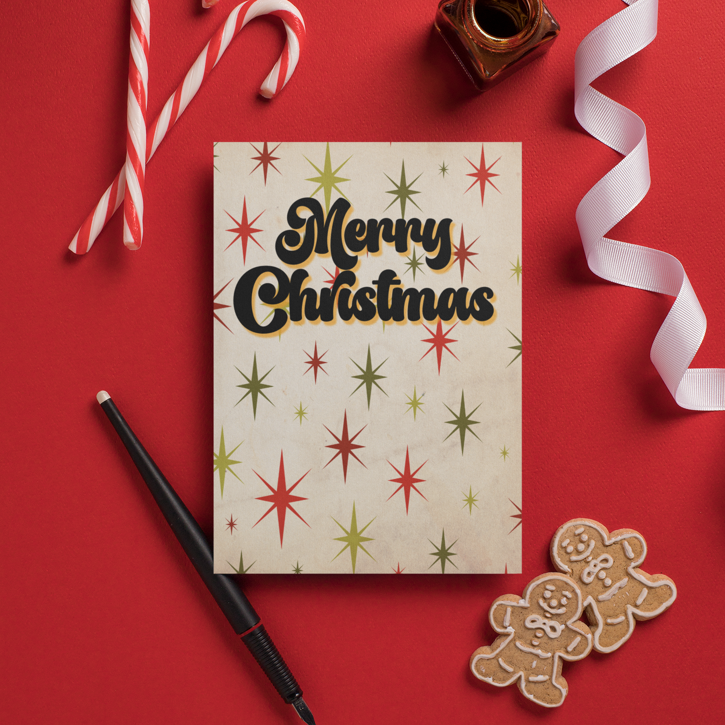 Christmas card with 'Merry Christmas' text on a red background with candy canes, ribbon, pen, and gingerbread cookies.
