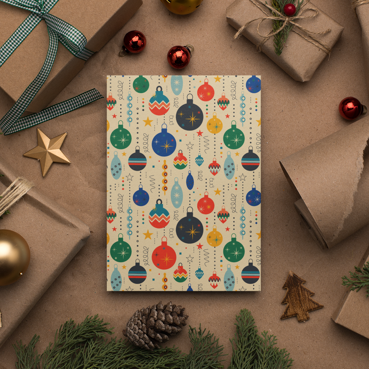Colorful Christmas ornament patterned card surrounded by gift wraps and festive decorations on a brown background